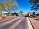 Gated community entrance with brick-paved road and well-maintained landscaping for enhanced security at 5049 Forest Oaks Dr, Las Vegas, NV 89149