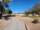 Scenic view of the golf course with mature trees and a walking path, perfect for outdoor recreation at 5049 Forest Oaks Dr, Las Vegas, NV 89149