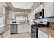 Updated kitchen featuring white cabinets, granite countertops, and stainless steel appliances at 5049 Forest Oaks Dr, Las Vegas, NV 89149