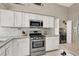 Modern kitchen with stainless steel appliances, white cabinets, and granite countertops at 5049 Forest Oaks Dr, Las Vegas, NV 89149