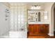 Bathroom featuring glass block accents, wood cabinets, walk-in shower and double sinks at 505 Los Dolces St, Las Vegas, NV 89138