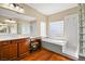 Spacious bathroom featuring a soaking tub, dual sinks, and glass block window at 505 Los Dolces St, Las Vegas, NV 89138