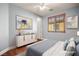 A staged bedroom features wood floors, modern decor, a ceiling fan and natural light at 505 Los Dolces St, Las Vegas, NV 89138