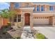 Inviting home exterior with stone accents, a well-manicured front yard, and a three-car garage at 505 Los Dolces St, Las Vegas, NV 89138