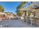 Community BBQ area featuring a grill, bar with seating, picnic table, and fire pit under a pergola, perfect for outdoor entertaining at 5055 W Hacienda Ave # 1116, Las Vegas, NV 89118