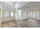 Open-concept living room with wood-style flooring, a vaulted ceiling, and large windows at 5216 Las Cruces Dr, Las Vegas, NV 89130