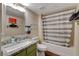 This bathroom has a striped shower curtain, tile floors and granite countertops at 524 Turtleback Rd # A, Mesquite, NV 89027