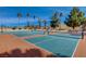 Well-maintained tennis courts with a vibrant blue and orange surface, enclosed by greenery, ideal for recreational activities at 524 Turtleback Rd # A, Mesquite, NV 89027