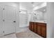 Bright bathroom featuring a shower-tub combo, white tile, and wood vanity with double sinks at 5398 Pico Viejo St, Las Vegas, NV 89166