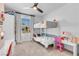 A bedroom featuring neutral carpet, a window, a ceiling fan, bunk beds, and two desks at 5398 Pico Viejo St, Las Vegas, NV 89166