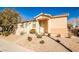 Inviting front entrance with a desert landscape and a quaint covered porch with beige stucco siding at 5575 Cresent Valley St, Las Vegas, NV 89148