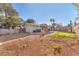 View of a large, partially landscaped backyard with covered patio, and block wall fence at 5640 Vasila Dr, Las Vegas, NV 89110