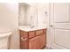 A well lit bathroom featuring a cherry wood vanity, a sink and a toilet with modern fixtures at 639 Grey Saker St, Las Vegas, NV 89138