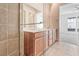 Bathroom featuring a double sink vanity with wood cabinets and a view of the bedroom with large windows at 639 Grey Saker St, Las Vegas, NV 89138