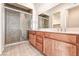 Bathroom showcasing a double sink vanity, a glass-enclosed shower with stone tiling, and tiled floors at 639 Grey Saker St, Las Vegas, NV 89138