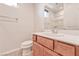 A well lit bathroom featuring a cherry wood vanity, a sink and a toilet at 639 Grey Saker St, Las Vegas, NV 89138