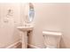 A modern bathroom with a pedestal sink and toilet under an oval mirror, blending essential features with a clean design at 639 Grey Saker St, Las Vegas, NV 89138