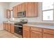 Kitchen with stainless steel appliances and wood cabinetry with granite countertops at 639 Grey Saker St, Las Vegas, NV 89138