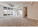 Bright living room featuring a ceiling fan, ample natural light from large windows, and sliding glass doors to the patio at 639 Grey Saker St, Las Vegas, NV 89138