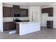 Modern kitchen features dark wood cabinets, an island with quartz countertops, and stainless appliances at 6616 Bowery St, Las Vegas, NV 89148