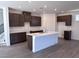 Modern kitchen with dark cabinets, white countertops, a central island, and stainless steel faucet at 6616 Bowery St, Las Vegas, NV 89148