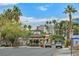 Street view of Las Vegas Country Club entrance with lush landscaping, and palm tree lined buildings at 668 Oakmont Ave # 1724, Las Vegas, NV 89109