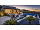 Modern backyard featuring pool, spa, fire pit, and covered patio with scenic views at sunset at 678 Blackrock Rim Dr, Henderson, NV 89012