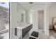 Bathroom with double sinks, modern fixtures, and a glass shower, complemented by natural light and mountain views at 678 Blackrock Rim Dr, Henderson, NV 89012