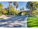 Community entrance featuring palm trees, lush greenery, and a covered entryway at 678 Blackrock Rim Dr, Henderson, NV 89012