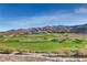 Expansive golf course with rolling hills, trees, and distant mountains, offering a picturesque view from the property at 678 Blackrock Rim Dr, Henderson, NV 89012