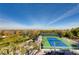 Elevated view of tennis court with well-maintained green and blue surface, landscaping and seating at 678 Blackrock Rim Dr, Henderson, NV 89012