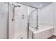 Bathroom showcasing glass-enclosed shower with white tiles and fixtures, a soaking tub, and shuttered window at 7106 Stanley Frederick St, Las Vegas, NV 89166