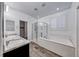 Bright bathroom featuring double vanity, glass-enclosed shower, and separate soaking tub with wood-look tile flooring at 7106 Stanley Frederick St, Las Vegas, NV 89166