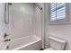 Bright bathroom features a shower-over-tub, white tile surround, and a window for natural light at 7106 Stanley Frederick St, Las Vegas, NV 89166