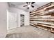 Bedroom featuring a wood-paneled accent wall, ceiling fan, carpet flooring, and closet at 7106 Stanley Frederick St, Las Vegas, NV 89166