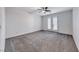 Empty bedroom with carpet flooring, ceiling fan, and double doors leading to a balcony at 7106 Stanley Frederick St, Las Vegas, NV 89166