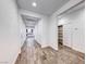 Bright hallway with wood-look tile flooring, white walls, and storage closet at 7106 Stanley Frederick St, Las Vegas, NV 89166