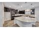 Modern kitchen features dark wood cabinetry, granite counters, stainless appliances, and a large island with pendant lighting at 7106 Stanley Frederick St, Las Vegas, NV 89166