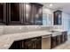 Dark wood cabinets line the kitchen with stainless appliances, granite countertops, tile backsplash, and a farmhouse sink at 7106 Stanley Frederick St, Las Vegas, NV 89166