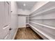 Walk-in pantry with white shelving and wood-look tile flooring at 7106 Stanley Frederick St, Las Vegas, NV 89166