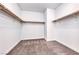 Spacious walk-in closet featuring carpet flooring and wooden shelves and rods for ample storage at 7106 Stanley Frederick St, Las Vegas, NV 89166