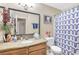 Well-lit bathroom with a granite countertop, decorative accents, and a patterned shower curtain at 7300 Pirates Cove Rd # 1062, Las Vegas, NV 89145