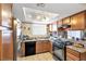 Functional kitchen featuring stainless steel refrigerator, oak cabinets, and a bright skylight at 7300 Pirates Cove Rd # 1062, Las Vegas, NV 89145