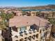 Aerial view of the home showcasing its tile roof, multiple balconies, and community near a lake at 75 Luce Del Sole # 3, Henderson, NV 89011