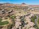 Expansive aerial view highlighting residential properties nestled by a lush golf course with mountainous terrain at 75 Luce Del Sole # 3, Henderson, NV 89011