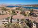 Stunning aerial view of lakeside property featuring terra cotta roofs, palm trees, and a beautiful lake in the background at 75 Luce Del Sole # 3, Henderson, NV 89011