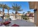 Relaxing outdoor balcony with palm trees and comfortable seating with red accents at 75 Luce Del Sole # 3, Henderson, NV 89011