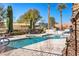 Relaxing community pool featuring a sun-soaked deck, comfortable seating, and lush landscaping at 75 Luce Del Sole # 3, Henderson, NV 89011