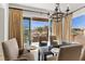 Open-concept dining room with backyard views, an elegant chandelier, and lots of natural light at 75 Luce Del Sole # 3, Henderson, NV 89011