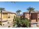 Stunning townhome complex with well-maintained landscaping, palm trees, and scenic lake views at 75 Luce Del Sole # 3, Henderson, NV 89011